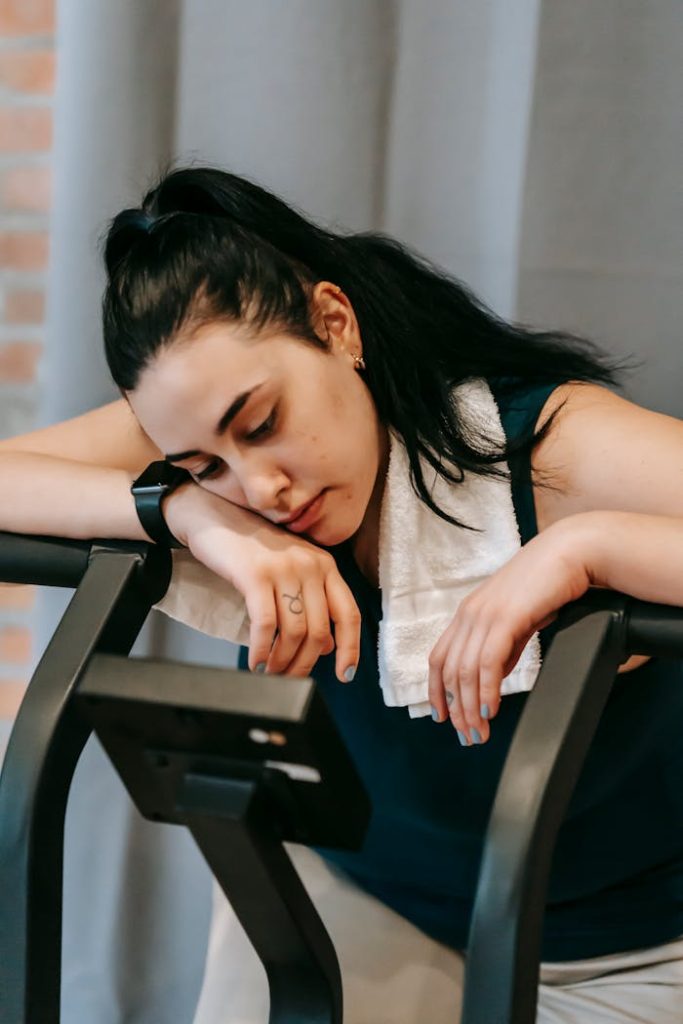 Exhausted young woman on exercise machine