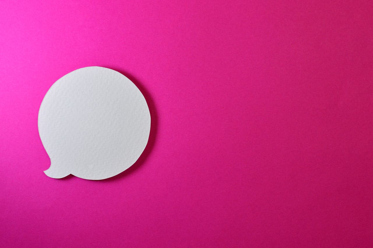 Minimalist pink background with a white speech bubble for creative design projects.