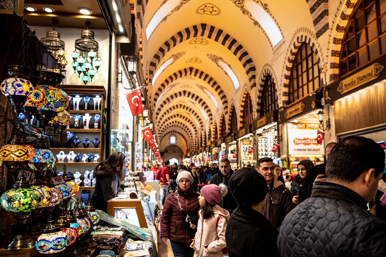 Colorful lamps and bustling crowd in Istanbul's historic Grand Bazaar, rich in culture and commerce.