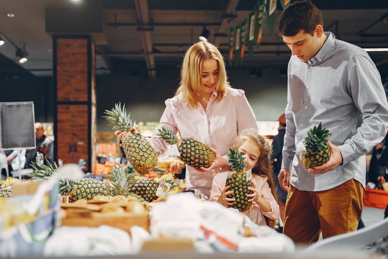 project-01-d A happy family shopping for fresh pineapples together in a supermarket.