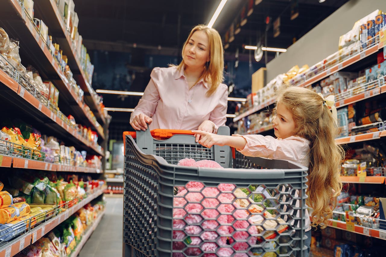 A mother and daughter enjoying time together shopping in a vibrant supermarket aisle.